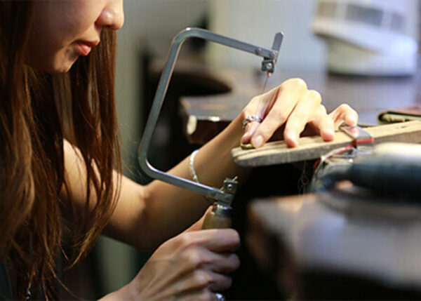 彫金で宝石ジュエリーを制作している女性